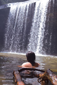 Rear view of woman looking at waterfall