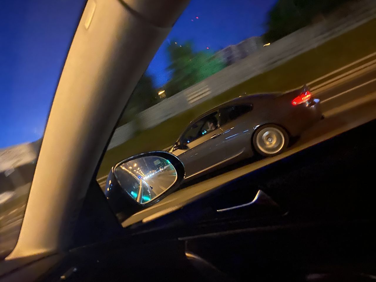 CLOSE-UP OF CAR MOVING ON ROAD IN MIRROR