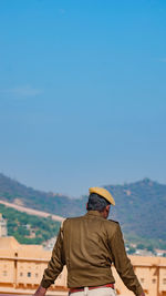 Rear view of man looking at mountain against sky