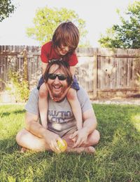 Happy father and son relaxing on grassy field