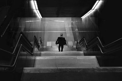 Rear view of man moving down steps