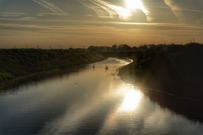 Scenic view of river against sky during sunset