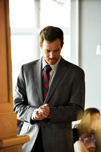 Confident young businessman standing at office