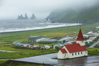 View of buildings by sea against sky