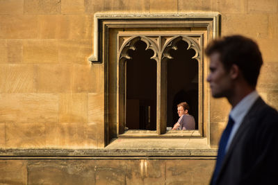 Woman standing by wall