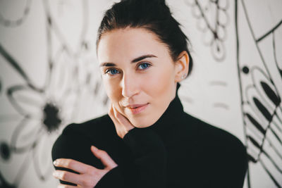 Portrait of beautiful woman standing against wall