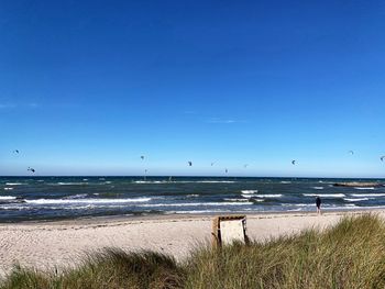 Scenic view of beach against blue sky