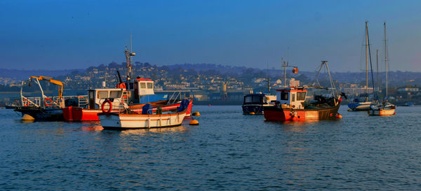 Boats on river against blue sky