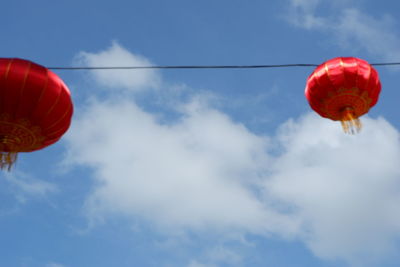 Low angle view of lanterns hanging against sky