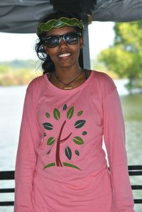 Portrait of smiling woman wearing sunglasses while standing against lake