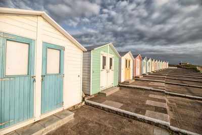 Row of houses on beach against sky