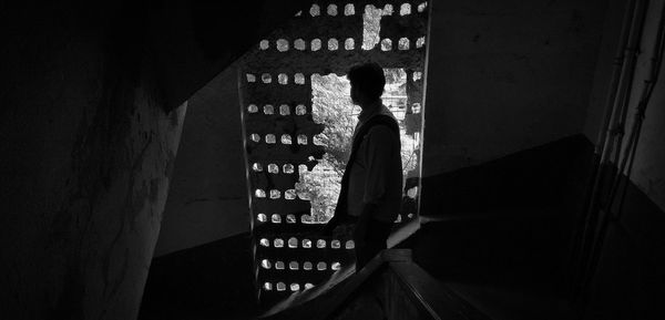 Man looking through window in building