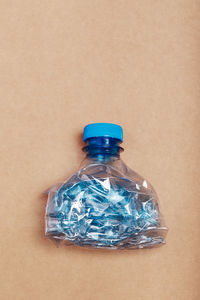 High angle view of plastic bottle against colored background