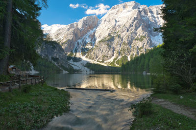 Scenic view of lake by mountains against sky