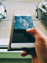 Close-up of man using smart phone on table