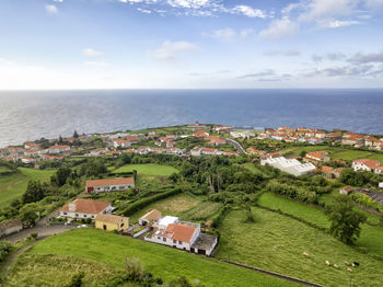 High angle view of town by sea against sky