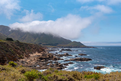 Scenic view of sea and mountains against sky