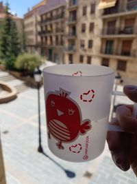 Close-up of hand holding coffee cup in city