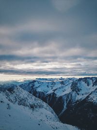 Scenic view of snowcapped mountains against cloudy sky