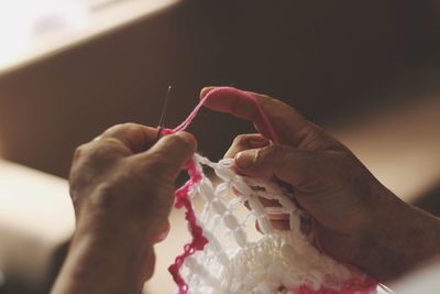 Cropped hands of woman making wool decoration