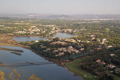 Aerial view of townscape and river against sky