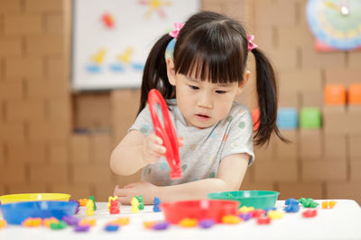 Cute girl with toys on table