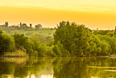 Scenic view of lake against sky at sunset