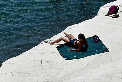 High angle view of woman sitting on shore