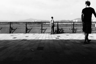 Full length of woman standing on railing