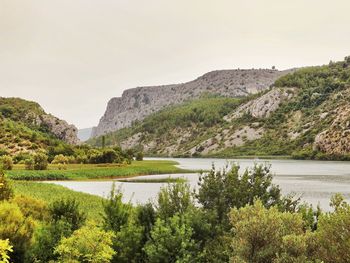 Scenic view of lake and mountains against clear sky