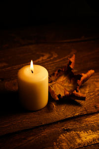 Close-up of lit candle on table