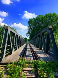 Footbridge over plants against sky