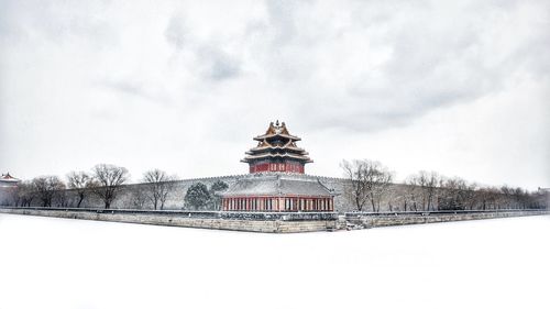 Snow covered building against sky