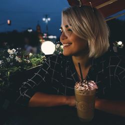 Close-up of a young woman drinking glass at restaurant