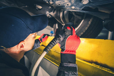 Rear view of man working in car