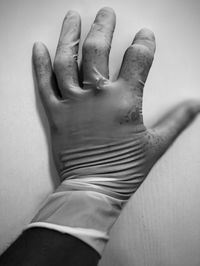 Close-up of hands on table against wall