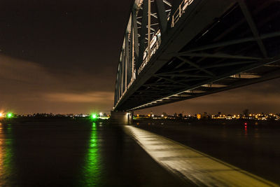 Illuminated suspension bridge over river at night