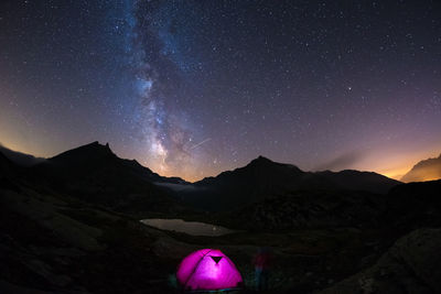 View of illuminated tent on mountain against sky at night