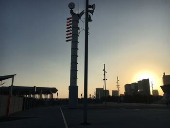 Street amidst buildings against clear sky during sunset