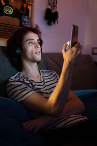 Man using mobile phone while sitting on sofa at home