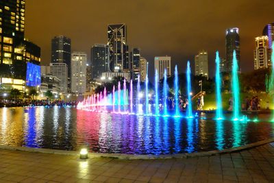 Illuminated buildings against sky at night