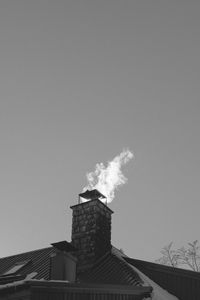 Low angle view of smoke emitting from chimney against sky