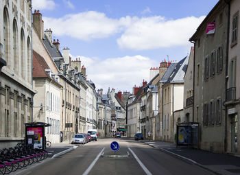 Cars on road amidst buildings against sky