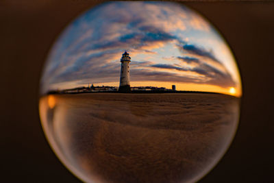 Close-up of glass against sunset sky