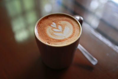 High angle view of coffee cup on wooden table