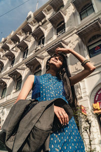 Low angle view of working woman on a sunny day in city.