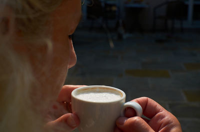 Woman drinking cappuccino - close-up