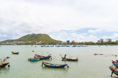 Boats moored on sea against sky