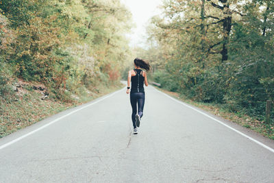 Rear view of man walking on road