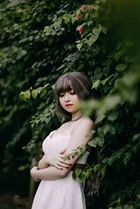 Portrait of woman standing against plants